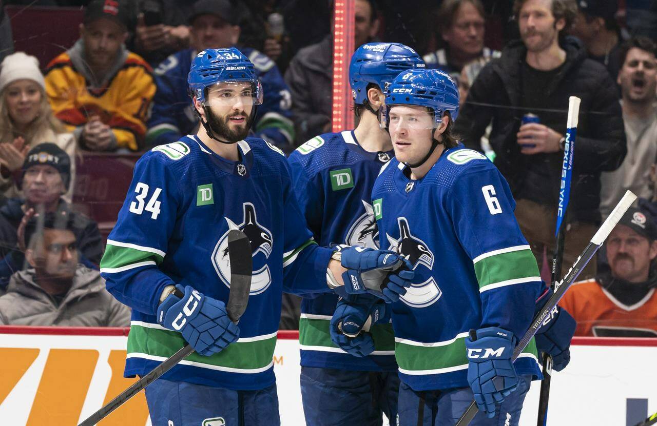 Vancouver Canucks’ Phillip Di Giuseppe (left) celebrates with teammate Brock Boeser after scoring a goal against the Philadelphia Flyers during third period NHL hockey action in Vancouver, B.C., Saturday, February 18, 2023. Di Giuseppe has agreed to a two-year, two-way contract extension with the Vancouver Canucks, the team announced Sunday. THE CANADIAN PRESS/Rich Lam