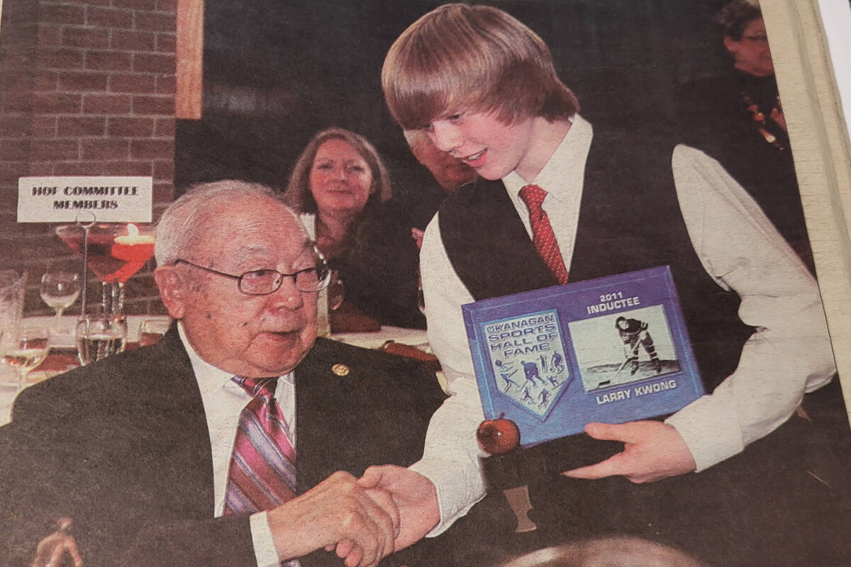 Vernon’s Larry Kwong is given his 2011 Okanagan Sports Hall of Fame induction plaque by Vernon student Gavin Donald. A push to have Kwong inducted into the Hockey Hall of Fame continues. (Morning Star - file photo)