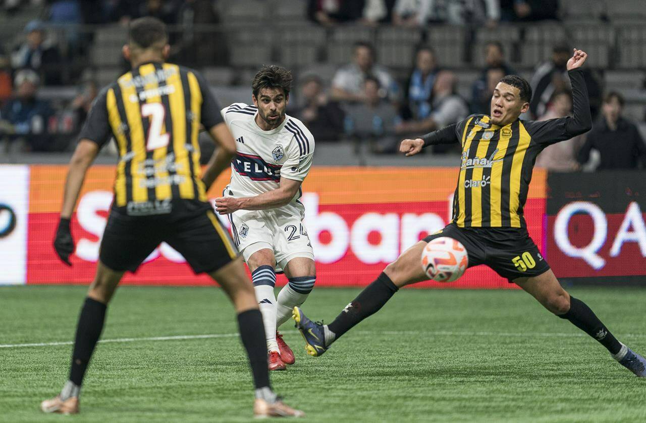 Vancouver Whitecaps FC’s Brian White (middle) fires a shot between the defence of Real Espana’s Junior Garcia (right) and Getsel Montes for a goal during second half CONCACAF Champions League soccer action in Vancouver, B.C., Wednesday, March 8, 2023. The Whitecaps advanced to the quarterfinals in CONCACAF Champions League play Wednesday after completing a 7-3 aggregate win over Honduran side Real CD Espana.THE CANADIAN PRESS/Rich Lam