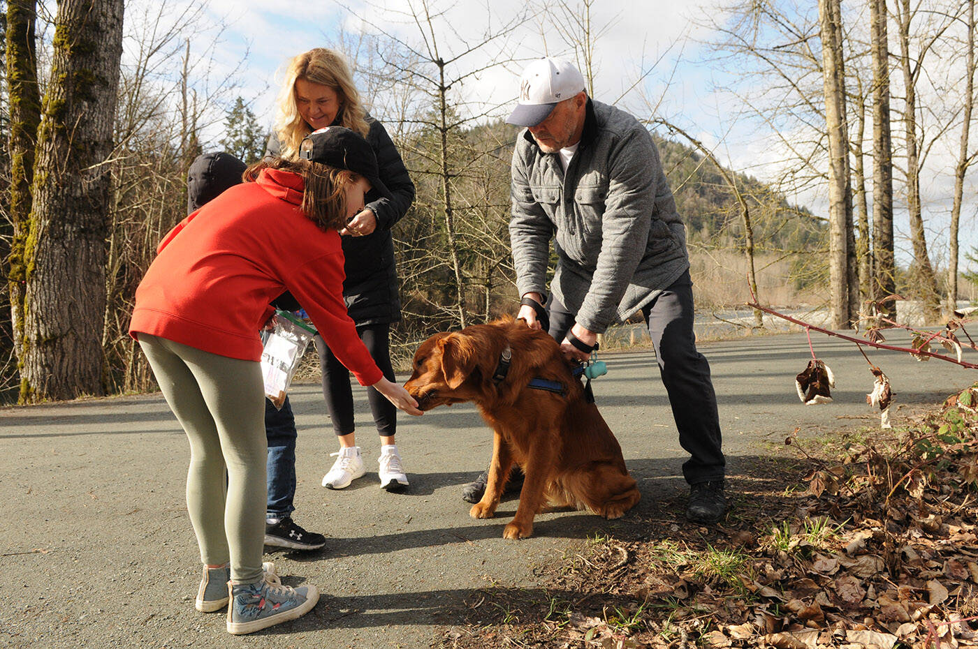 Jade Pennock gives a dog a treat near Vedder Park during Watson Elementary’s Kindness Project on Wednesday, March 15, 2023. (Jenna Hauck/ Chilliwack Progress)
