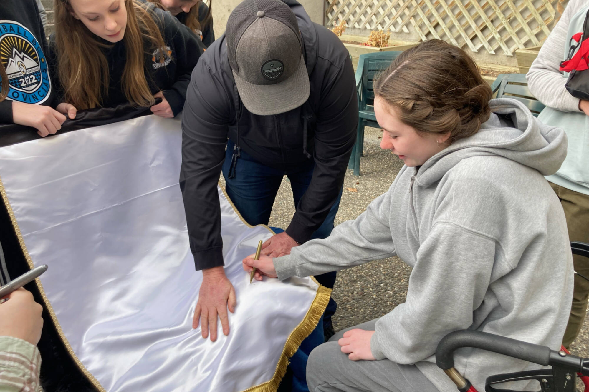 Autumn Saville signs the U15 female hockey league banner won on March 12, 2023, which her teammates brought to her at Shuswap Lake General Hospital where she was recovering from a burst appendix. (Photo contributed)