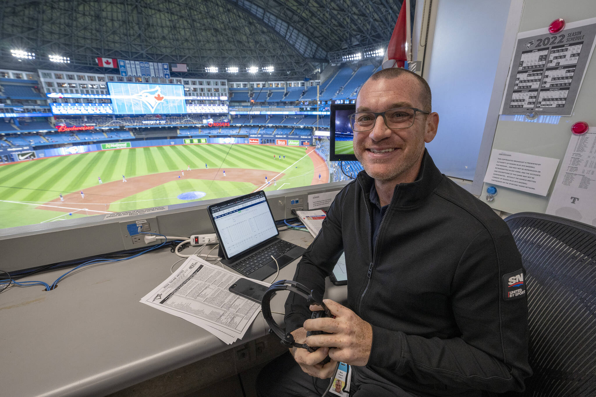 Toronto Blue Jays announcer Ben Wagner sits in the broadcast booth in Toronto, Sunday, April 10, 2022. Sportsnet, the Blue Jays’ radio rightsholder, will not resume on-site radio broadcasts for the 2023 regular season and will instead use remote coverage from its downtown Toronto studio for road games. THE CANADIAN PRESS/Frank Gunn